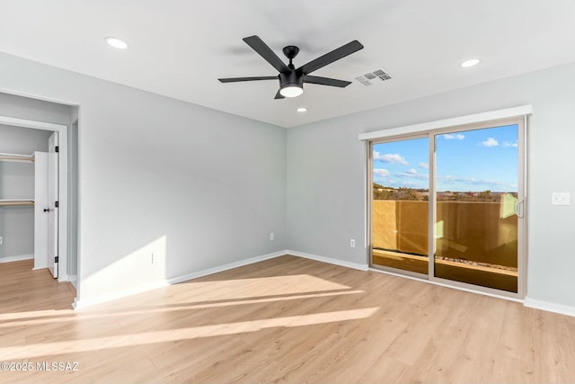 empty room with light wood-type flooring, baseboards, and visible vents