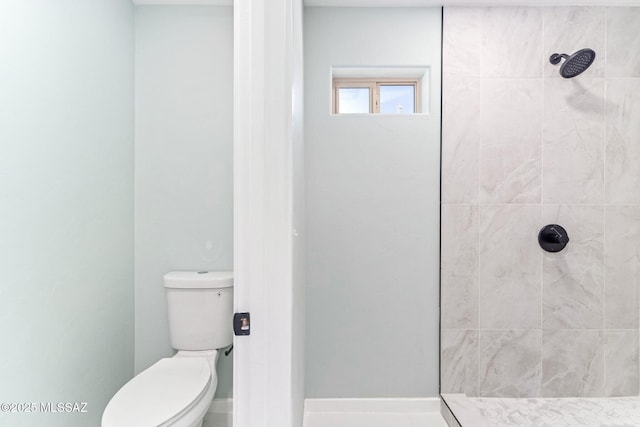 full bath with a tile shower and toilet