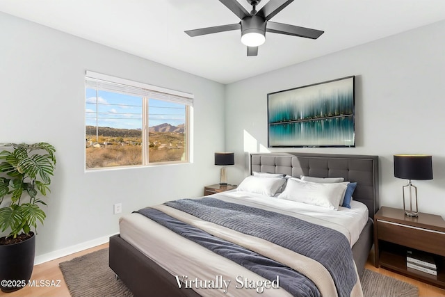 bedroom featuring wood finished floors, a ceiling fan, and baseboards