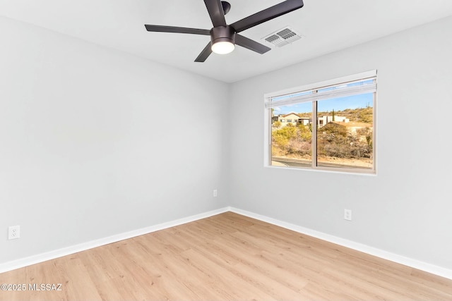 empty room featuring ceiling fan, light wood-style floors, visible vents, and baseboards