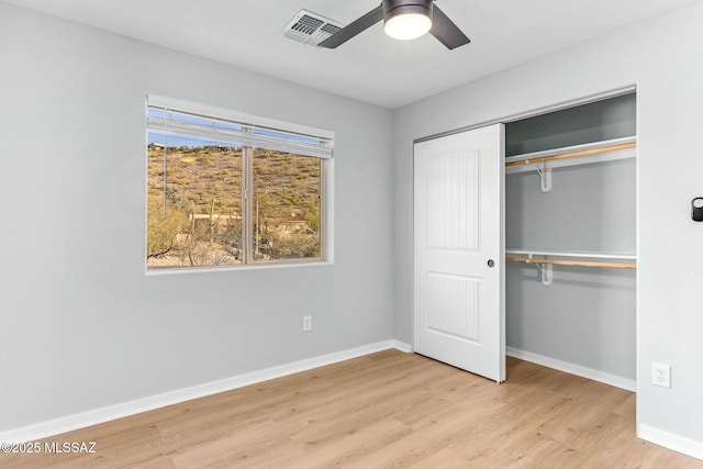 unfurnished bedroom with ceiling fan, visible vents, baseboards, light wood-style floors, and a closet