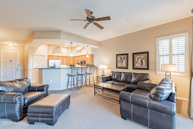 carpeted living room with ceiling fan