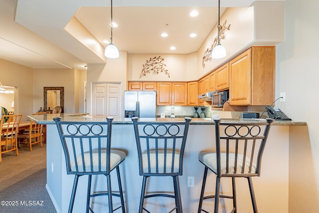 5775 S Camino Del Sol Unit 5203, Green Valley, AZ 85622 - kitchen featuring decorative light fixtures, a breakfast bar area, kitchen peninsula, and appliances with stainless steel finishes