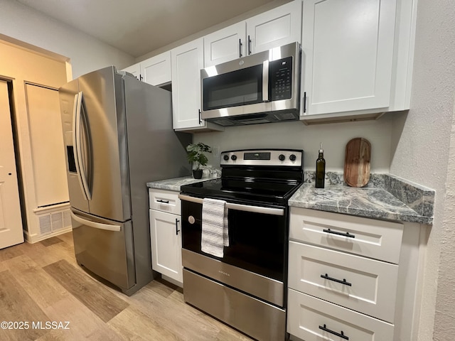 kitchen featuring light stone countertops, white cabinetry, and appliances with stainless steel finishes