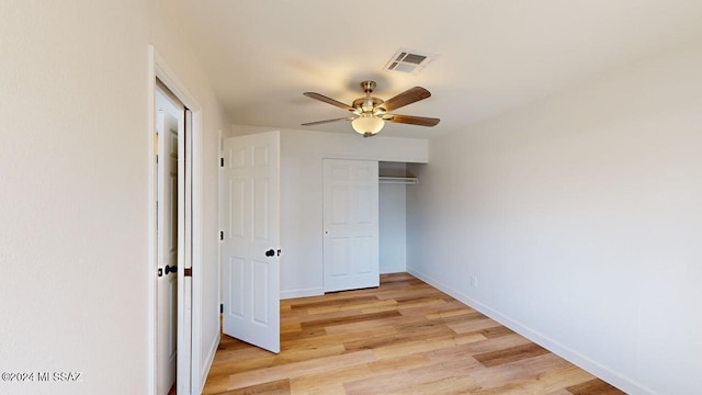 unfurnished bedroom featuring ceiling fan, a closet, and light hardwood / wood-style flooring