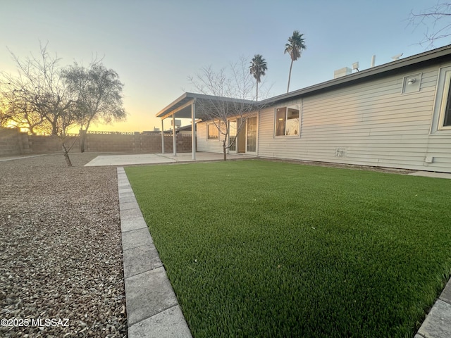 yard at dusk featuring a patio