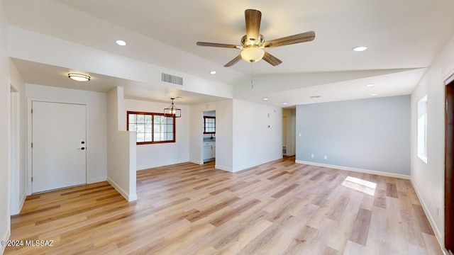 unfurnished living room featuring ceiling fan, vaulted ceiling, and light wood-type flooring