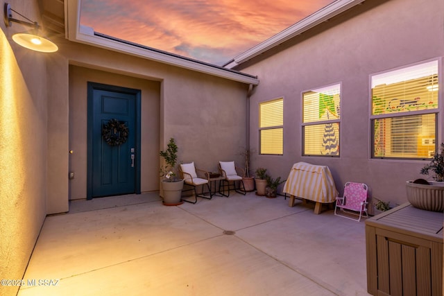 exterior entry at dusk with a patio area