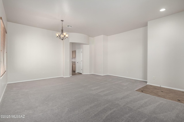 unfurnished room featuring carpet flooring and a chandelier