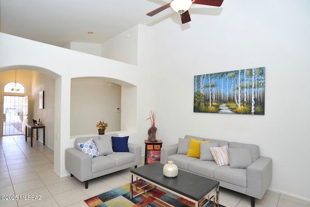 living room with light tile patterned flooring, a towering ceiling, and ceiling fan