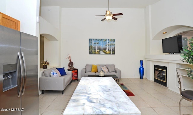 tiled living room with a high ceiling and ceiling fan