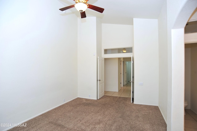 spare room featuring ceiling fan and light carpet