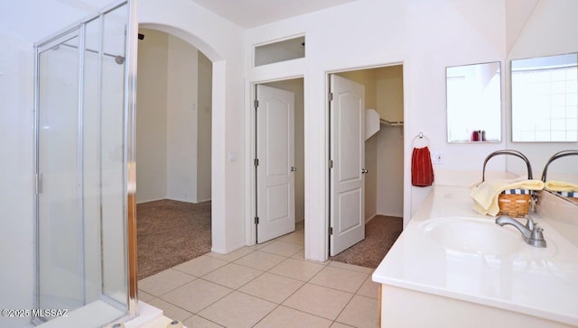 bathroom featuring tile patterned flooring, vanity, and a shower with door