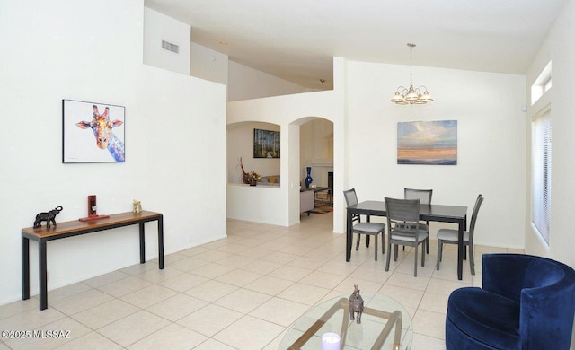 tiled dining area featuring lofted ceiling and a chandelier