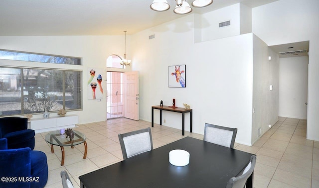 dining room with light tile patterned flooring, high vaulted ceiling, and a notable chandelier