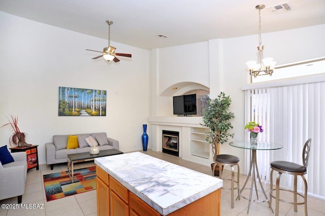 tiled living room featuring ceiling fan with notable chandelier