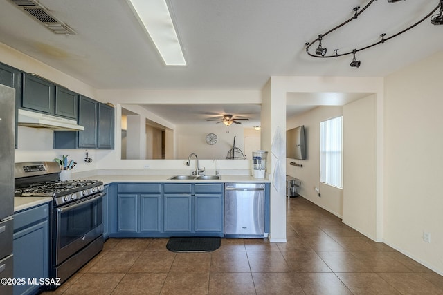 kitchen featuring sink, ceiling fan, stainless steel appliances, blue cabinets, and dark tile patterned flooring