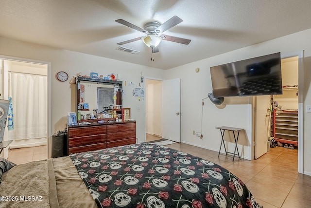 tiled bedroom with a textured ceiling and ceiling fan