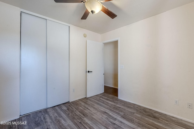 unfurnished bedroom featuring hardwood / wood-style flooring, ceiling fan, and a closet