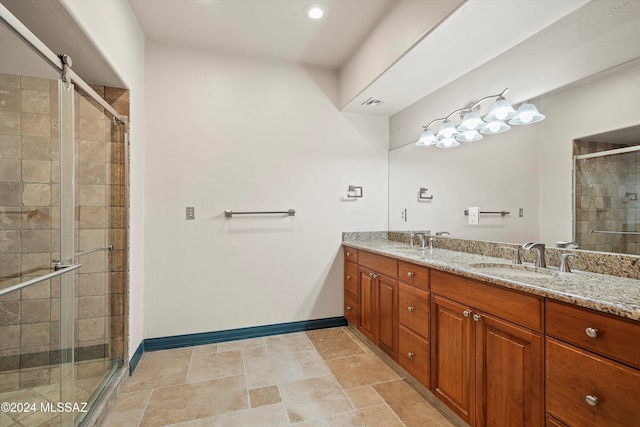 bathroom with a sink, a shower stall, baseboards, and double vanity