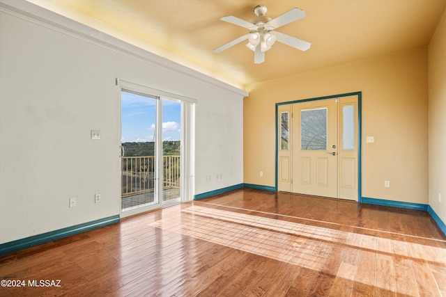 foyer entrance with hardwood / wood-style flooring, ceiling fan, and baseboards