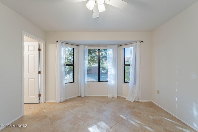 tiled spare room with ceiling fan and plenty of natural light