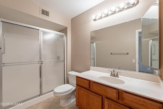 bathroom with vanity, toilet, tile patterned floors, and walk in shower