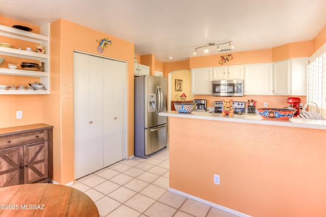 kitchen with stainless steel appliances, white cabinetry, sink, and light tile patterned floors