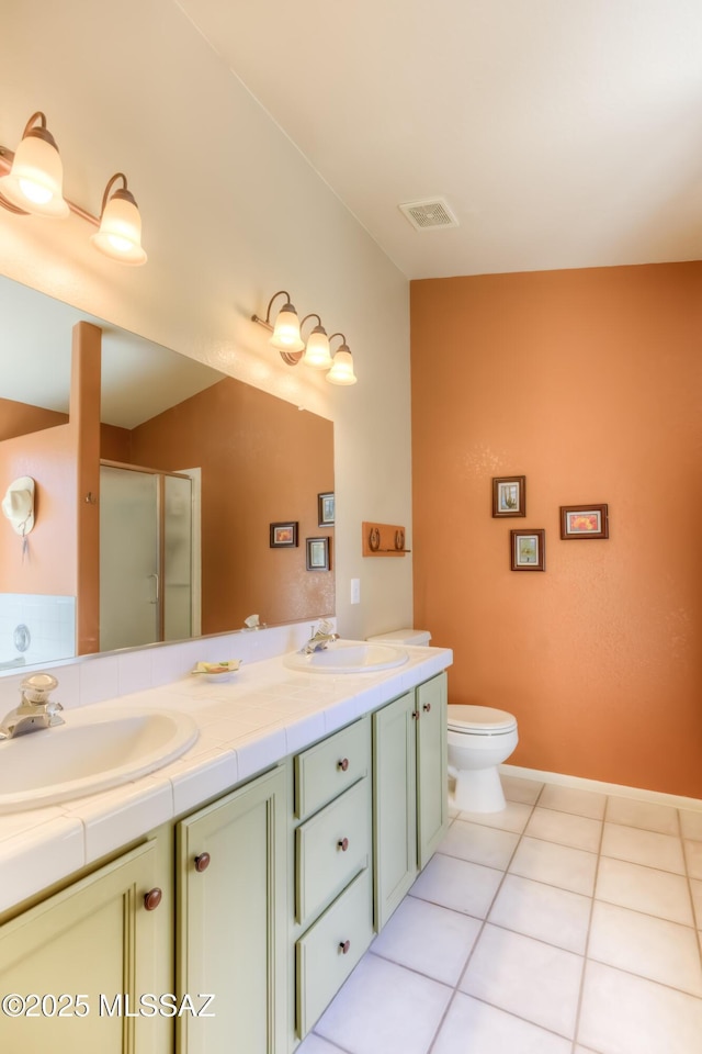 bathroom featuring vanity, toilet, an enclosed shower, and tile patterned flooring