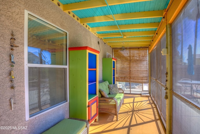 unfurnished sunroom with beamed ceiling