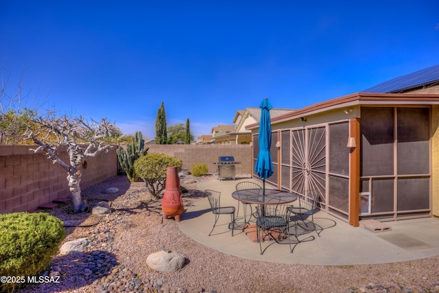 view of patio featuring grilling area and a sunroom