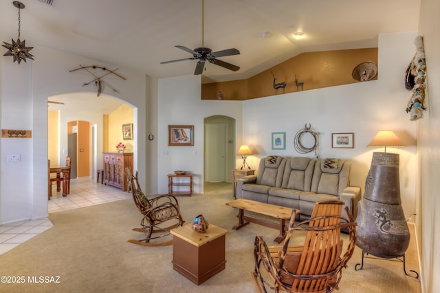 carpeted living room with high vaulted ceiling and ceiling fan