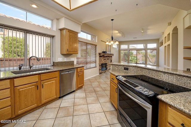 14686 N Lost Arrow Dr, Oro Valley, AZ 85755 - kitchen with sink, light tile patterned floors, stainless steel appliances, a fireplace, and a chandelier