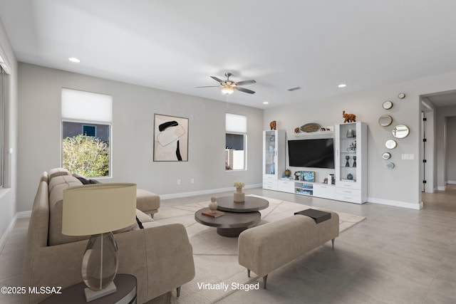 living area featuring baseboards, plenty of natural light, and recessed lighting