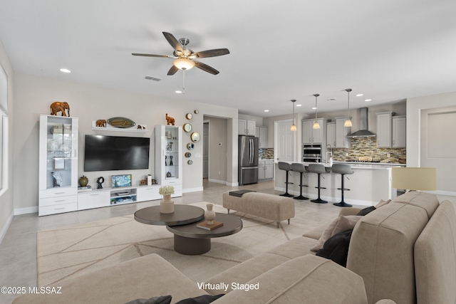 living area with a ceiling fan, visible vents, recessed lighting, and baseboards