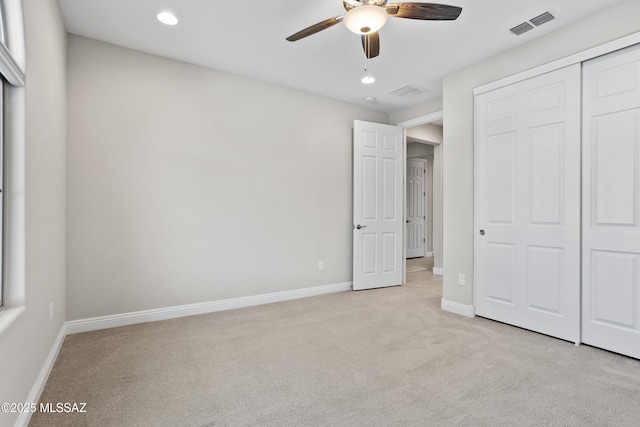 unfurnished bedroom with light colored carpet, recessed lighting, visible vents, baseboards, and a closet