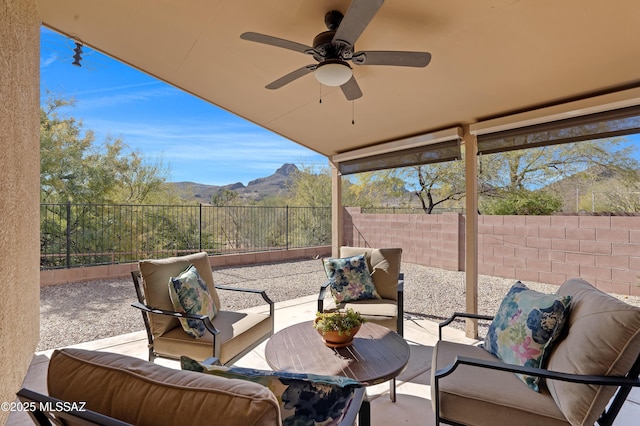 view of patio with a mountain view, an outdoor living space, and ceiling fan