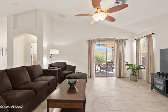 living room featuring vaulted ceiling, light tile patterned floors, and ceiling fan