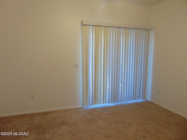 carpeted empty room with baseboards