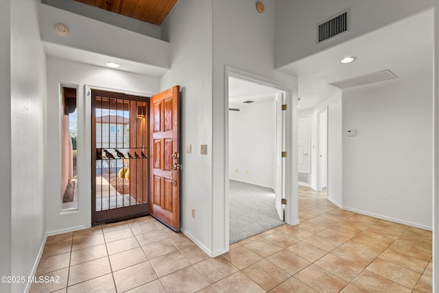 tiled foyer with a towering ceiling