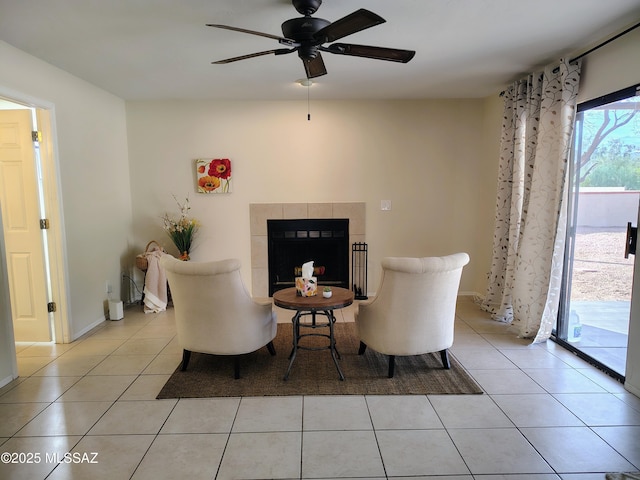 living area featuring light tile patterned floors, a fireplace, and a ceiling fan