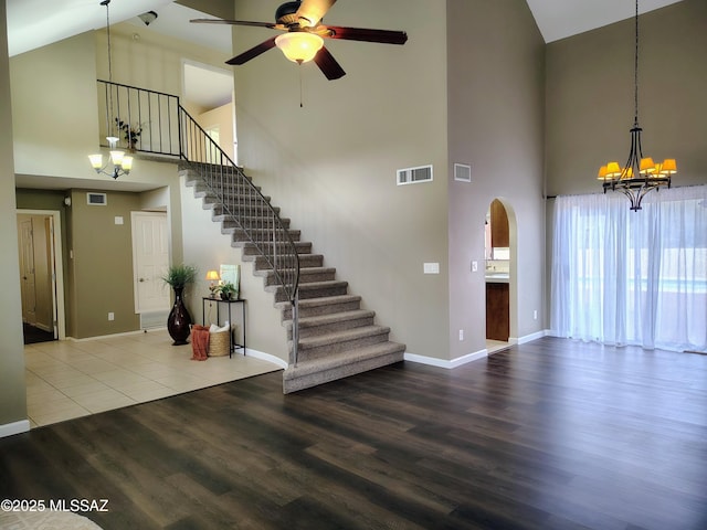 interior space with stairs, ceiling fan with notable chandelier, wood finished floors, and visible vents