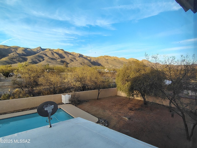 view of pool featuring a patio, fence, and a mountain view