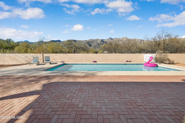 view of pool with a patio area, fence, a mountain view, and a fenced in pool