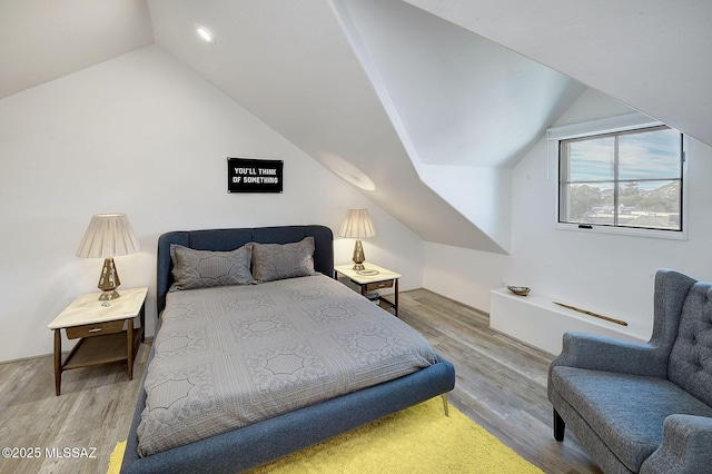 bedroom with vaulted ceiling and light hardwood / wood-style flooring