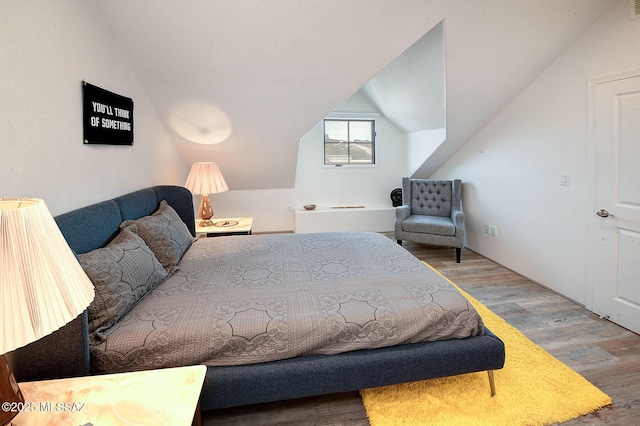 bedroom featuring hardwood / wood-style flooring and lofted ceiling