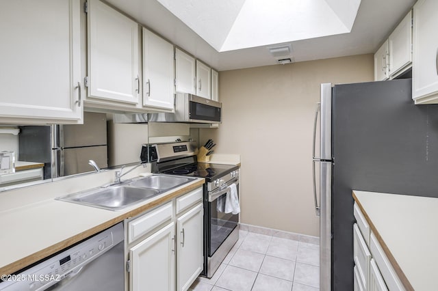 kitchen with white cabinetry, sink, light tile patterned floors, and stainless steel appliances