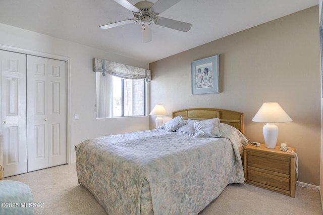 bedroom featuring light colored carpet, a closet, and ceiling fan