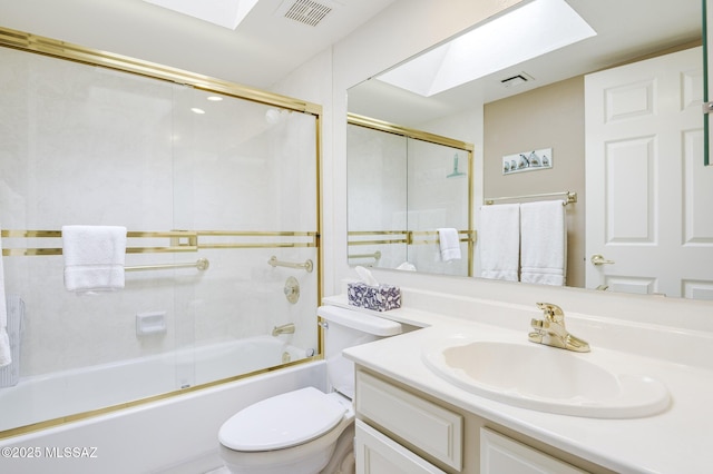 full bathroom with vanity, toilet, a skylight, and combined bath / shower with glass door