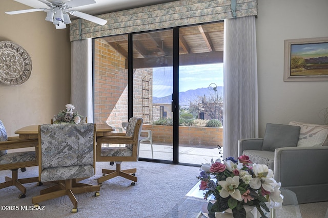 interior space with ceiling fan, carpet flooring, and a mountain view